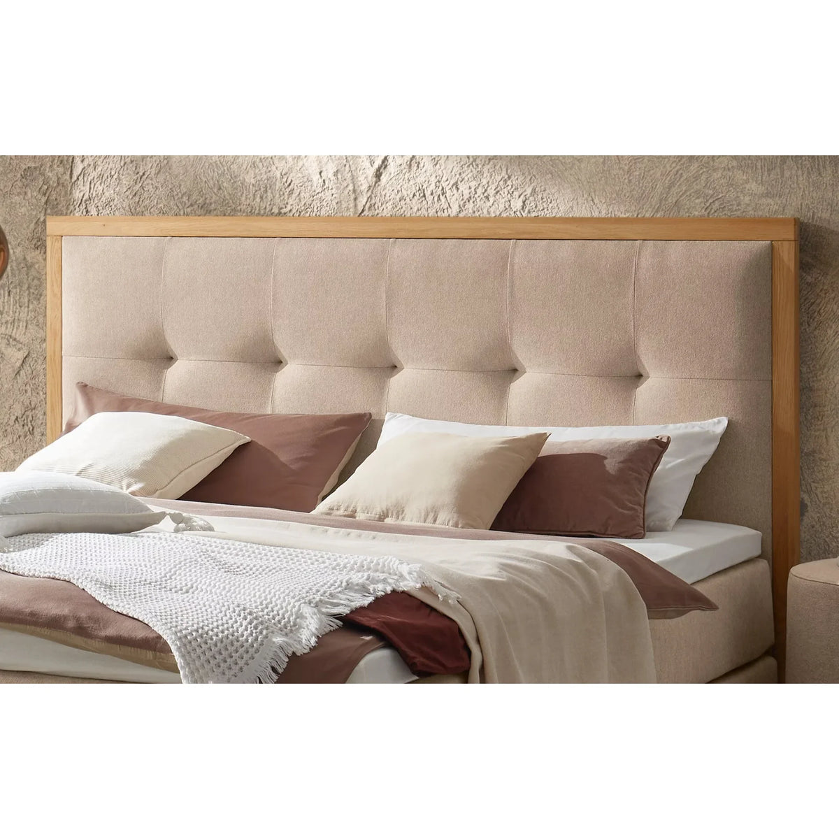 Modernes Polsterbett mit Holzrahmen und beige-braunem Kopfteil mit Dekokissen