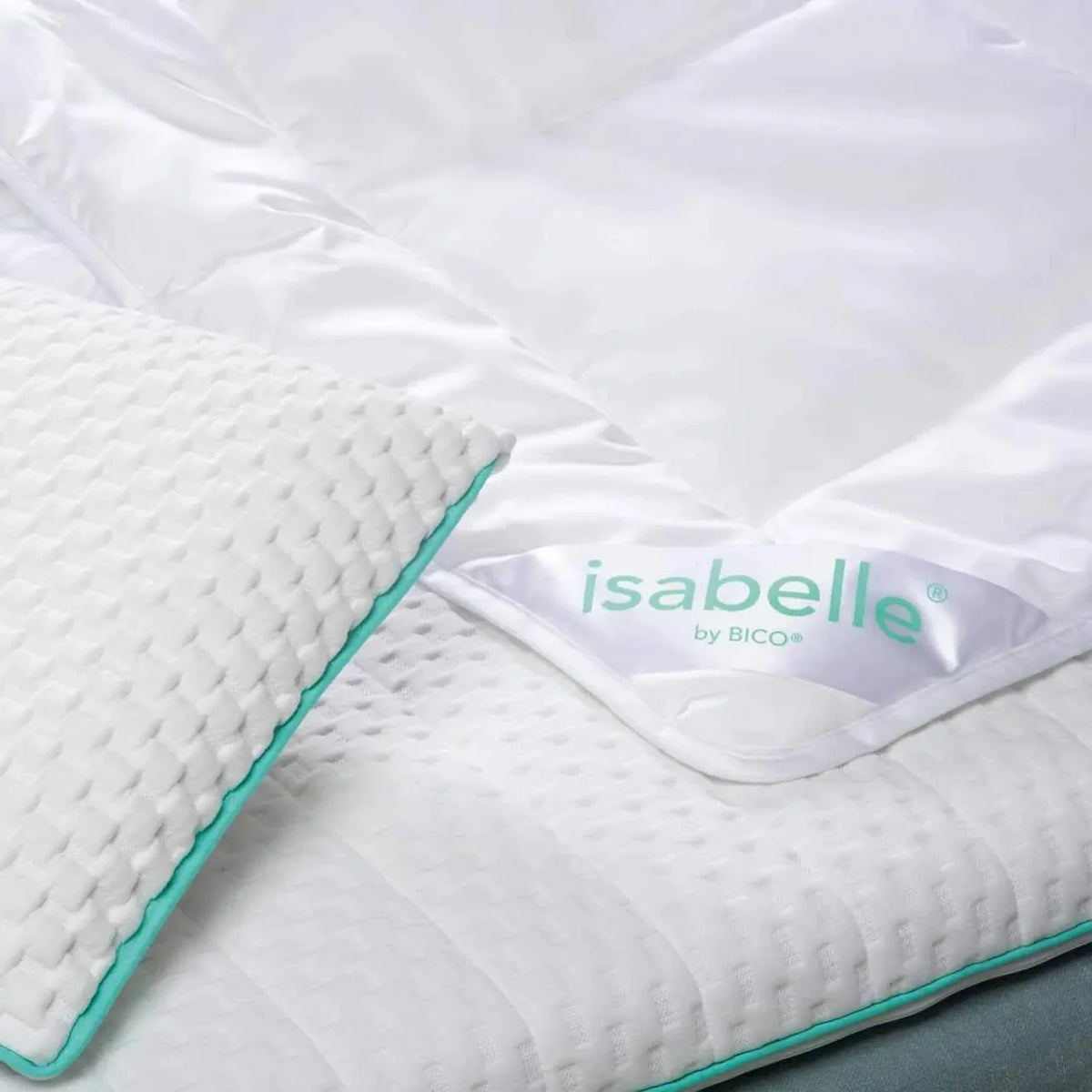 Isabelle by Bico Sommerdaunen mit türkisem Rand und Etikett auf weißem Bett