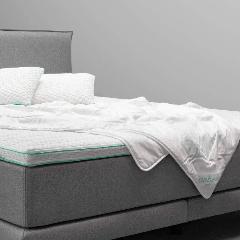 Isabelle by BICO Sommerduvet auf grauem Boxspringbett mit weißen Kissen und Bettwäsche.
