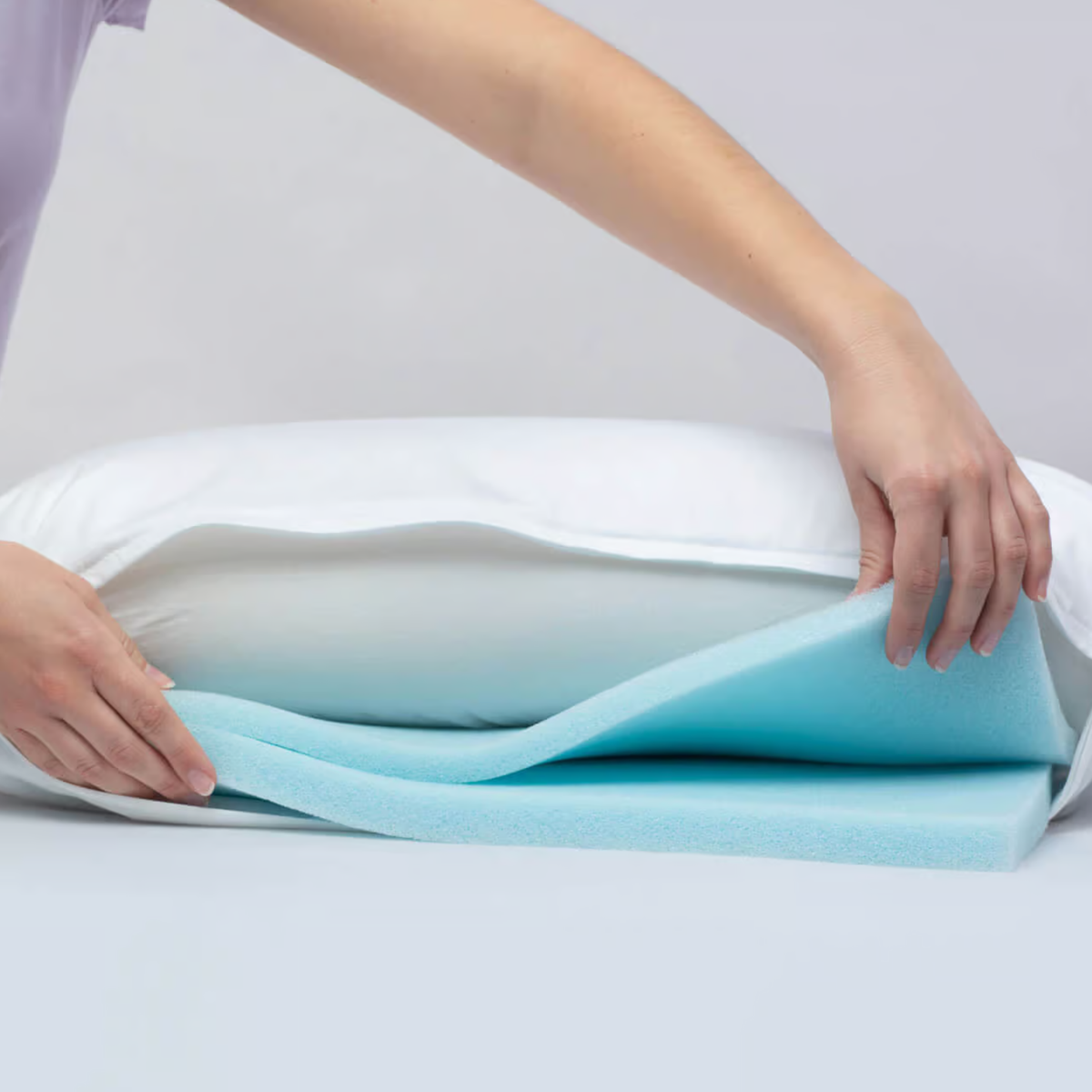 Bico Clima Flow Kissen 40x60 mit herausnehmbarer blauer Kühlschaum-Einlage, von Händen geöffnet