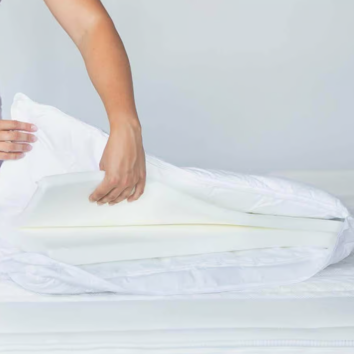 Clima Luxe Vario Kissen 50x70 cm – Hände legen Schaumstoffkissen in weissen Kissenbezug ein