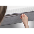 Frau öffnet Reißverschluss des abnehmbaren Bezugs der Bico Matratze Basics 90x200 cm in Grau/Weiß