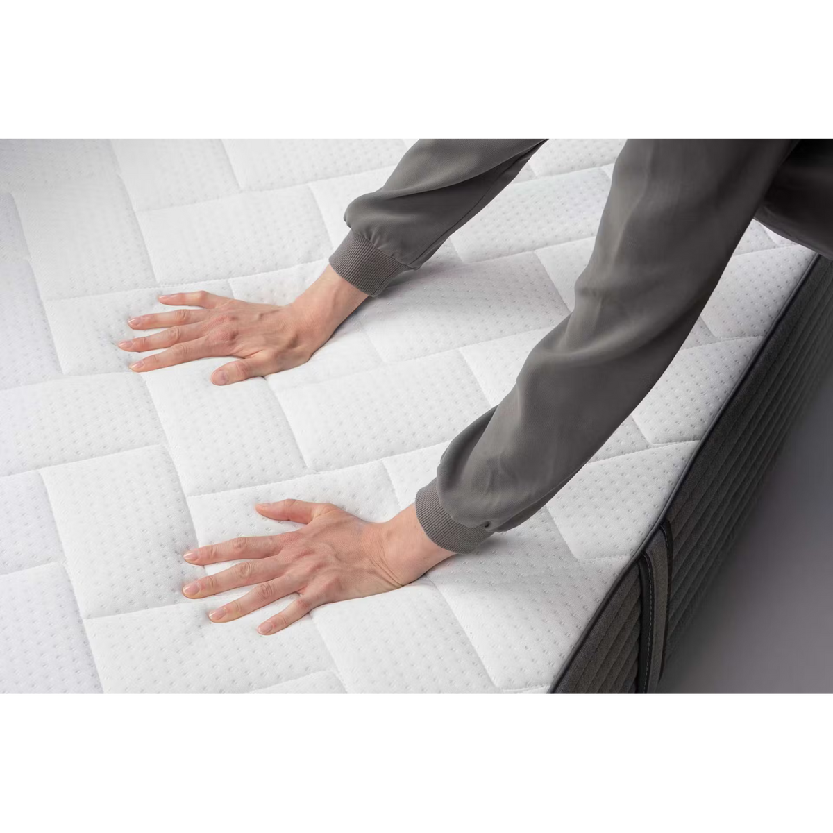 Person testet die Festigkeit der Bico Basics 4 Matratze 90x200 cm mit beiden Händen