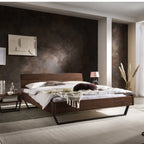 Modernes Schlafzimmer mit Holzbett, dunkler Akzentwand und eleganter Einrichtung - Schweizer Design.