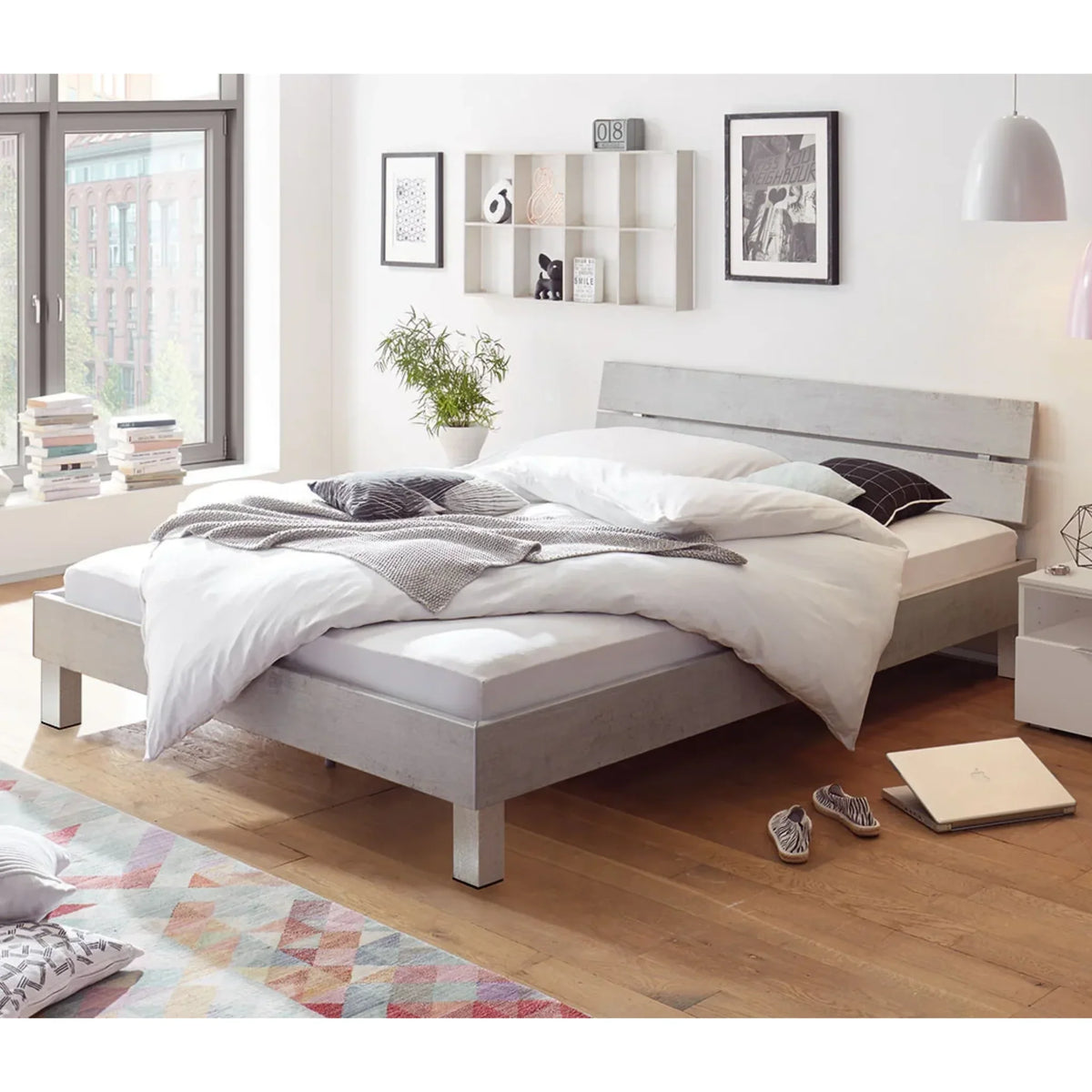 Hasena Movie Line Designbett Nia - modernes Schlafzimmer mit grauem Bett, weißer Bettwäsche und Holzboden.